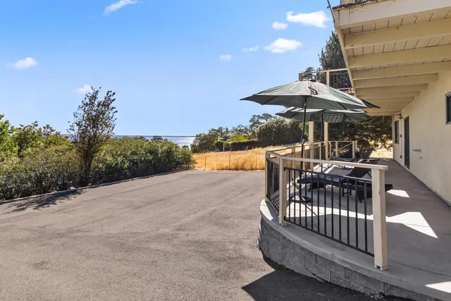 a balcony with furniture and umbrella