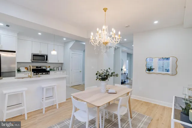 a kitchen with stainless steel appliances kitchen island granite countertop a dining table and chairs in it