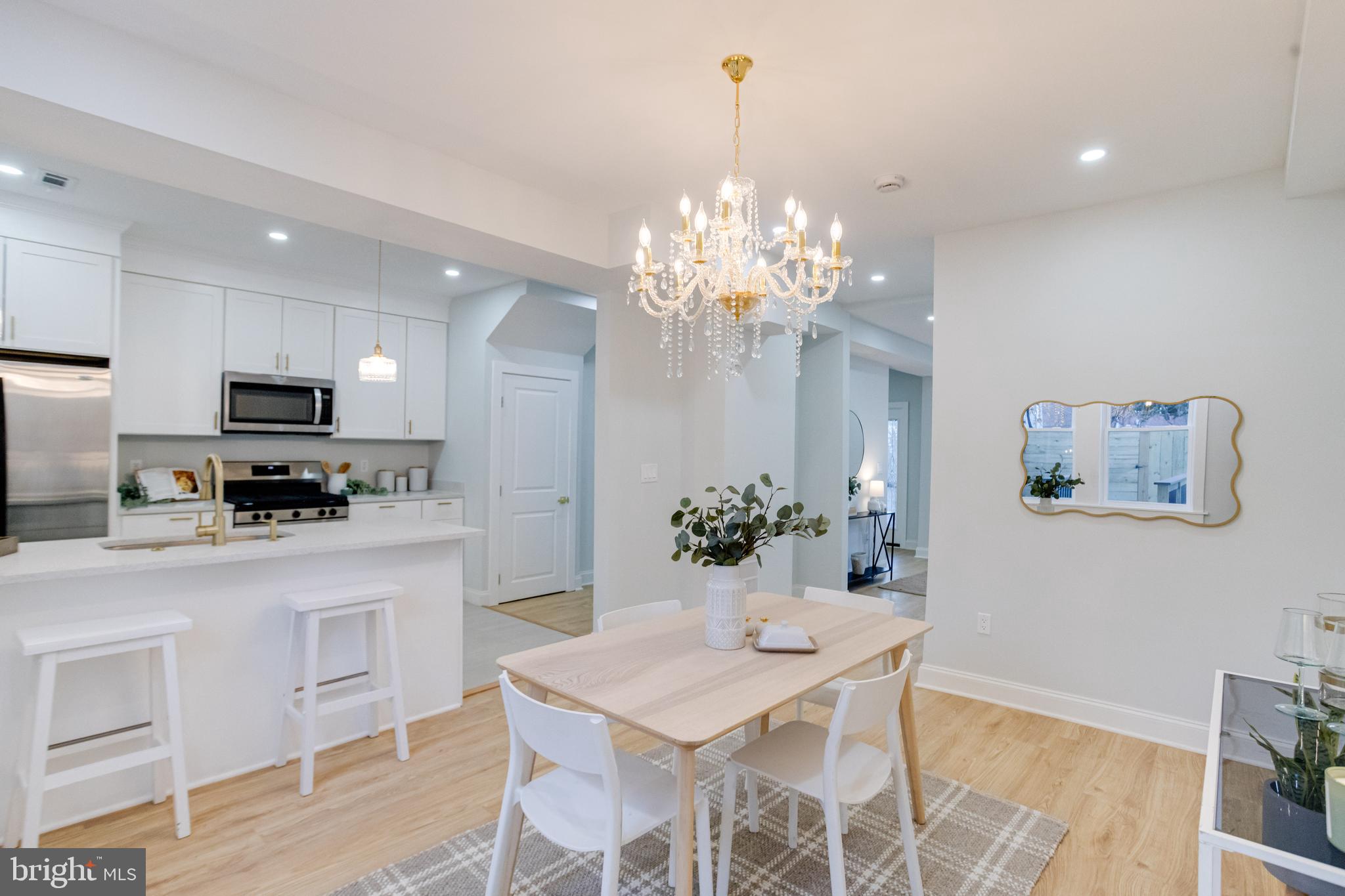 a kitchen with stainless steel appliances kitchen island granite countertop a dining table and chairs in it