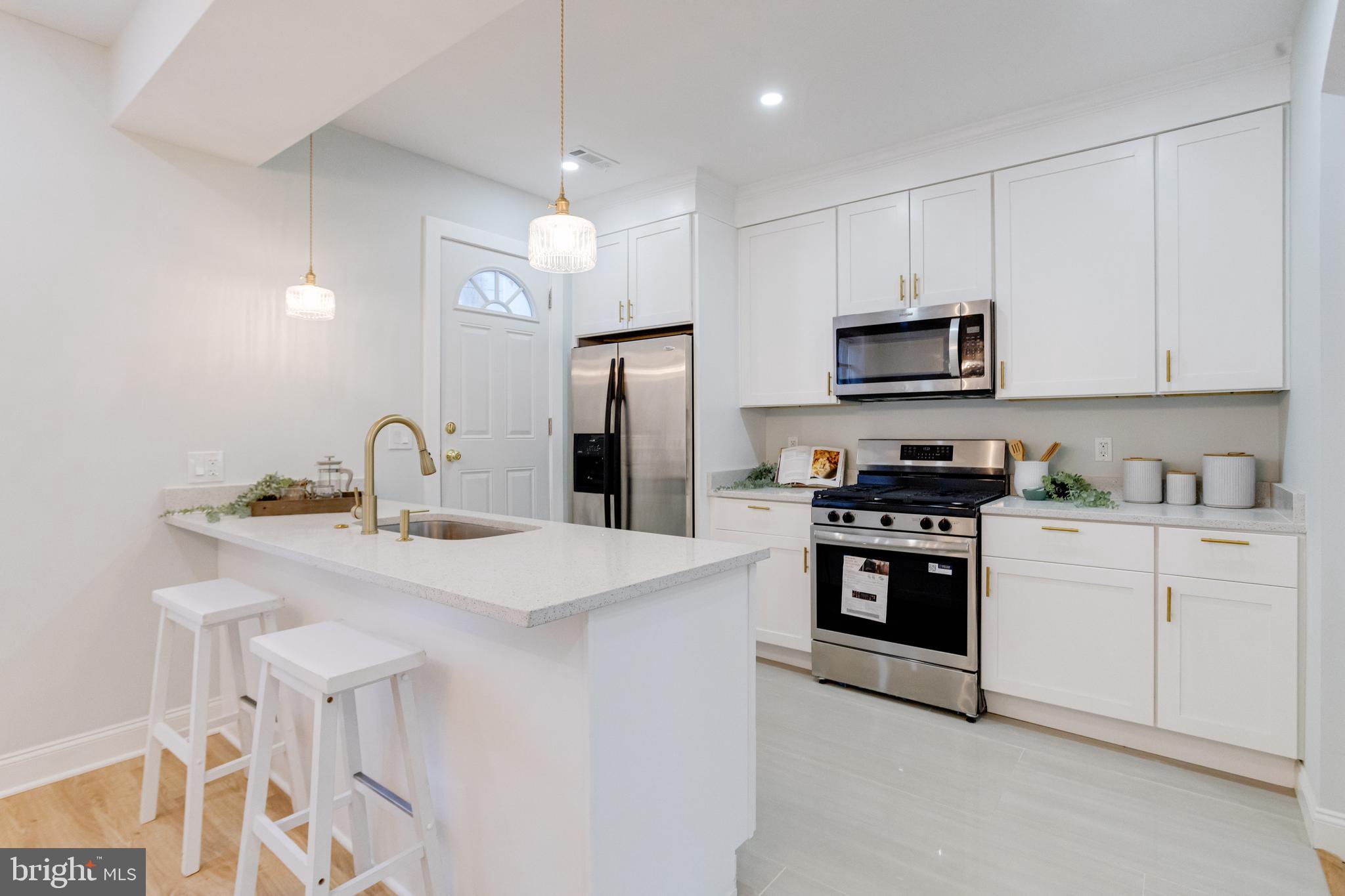 635 North Rosedale Street Baltimore, MD 21216 - Photo 4 of 64 a kitchen with stainless steel appliances a sink a stove a refrigerator cabinets and a window