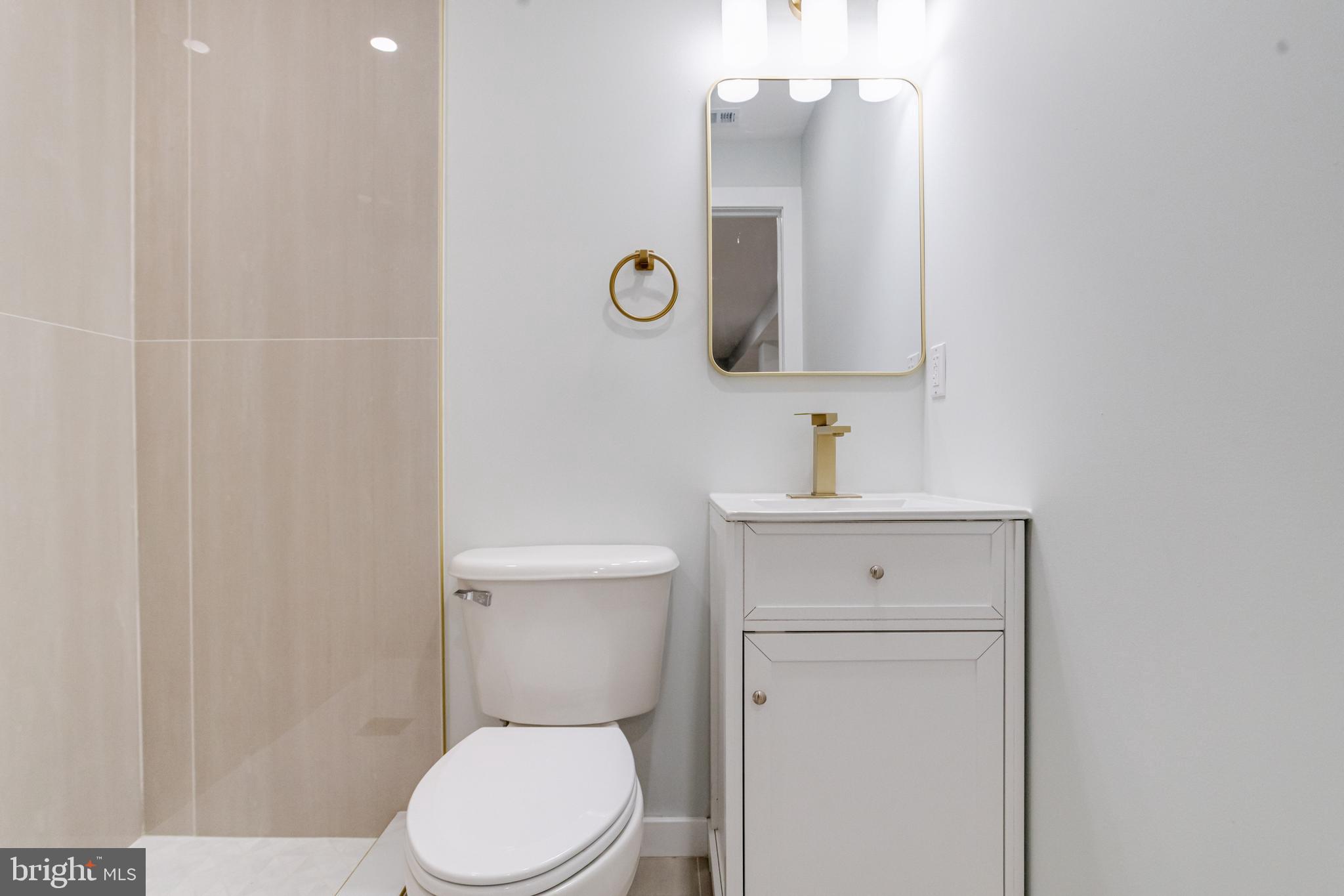 635 North Rosedale Street Baltimore, MD 21216 - Photo 47 of 64 a bathroom with a toilet sink vanity and mirror