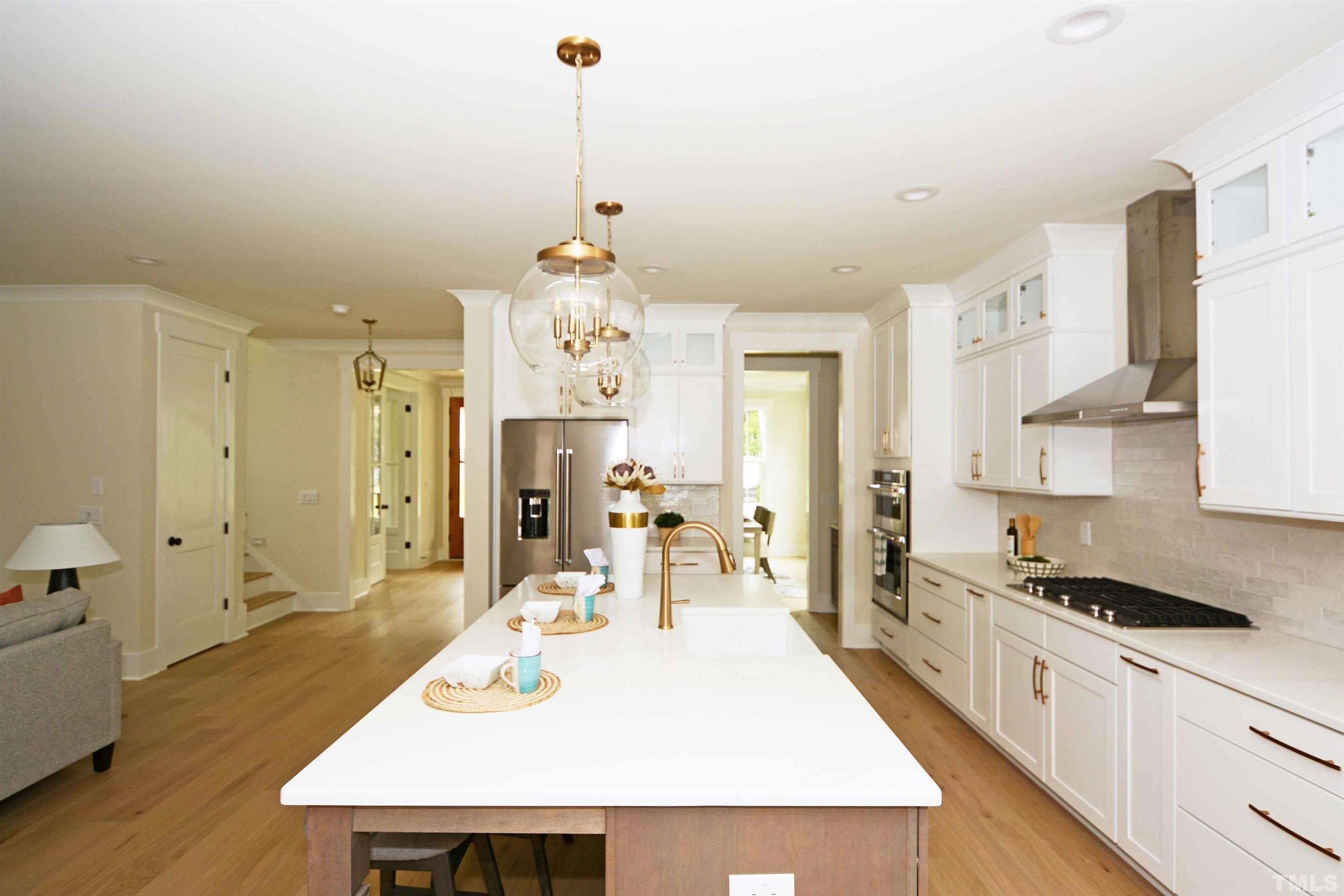 725 Mial Street Raleigh, NC 27608 - Photo 8 of 26 a kitchen with stainless steel appliances a dining table chairs and white cabinets