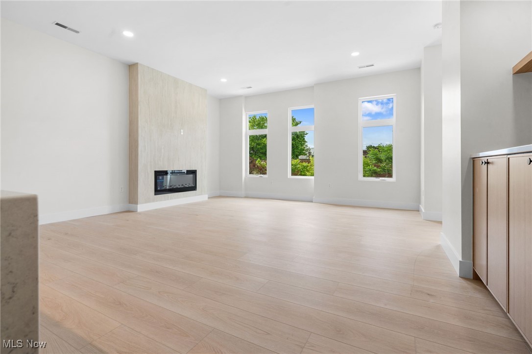 Unfurnished living room featuring light wood-style floors, a fireplace, and recessed lighting