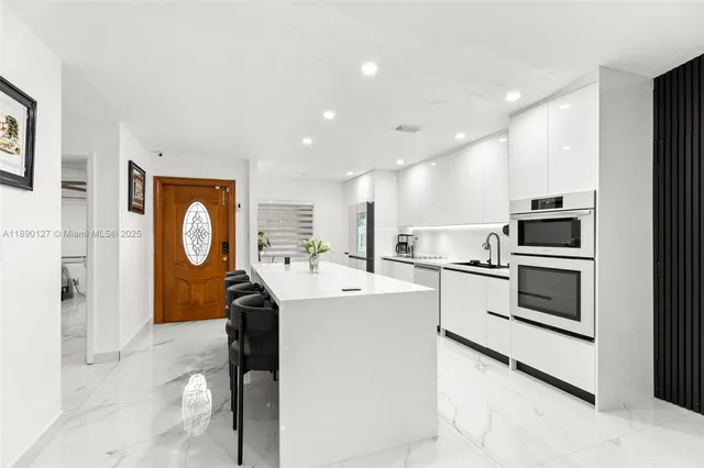 a kitchen with white cabinets and white appliances