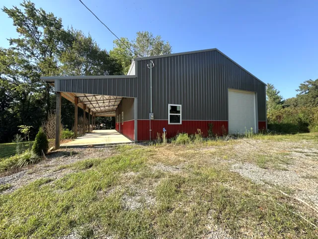 a backyard of a house with wooden fence and large trees