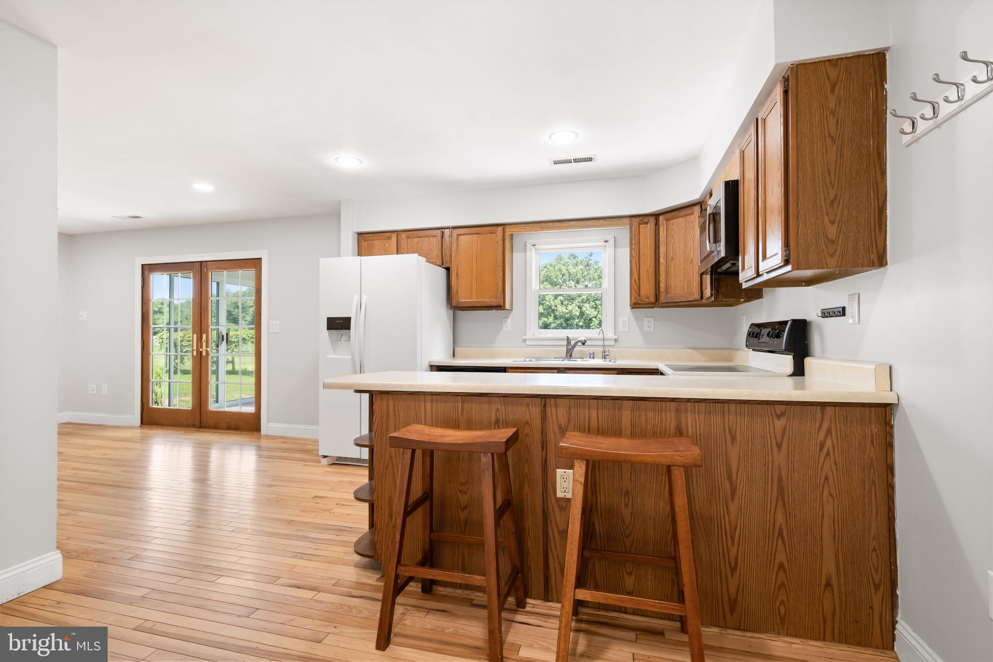 26648 Arcadia Shores Road Easton, MD 21601 - Photo 11 of 25 a kitchen with stainless steel appliances granite countertop wooden cabinets a sink a stove a dining table and chairs