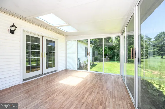 a view of empty room with wooden floor and pool