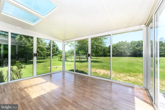 a view of empty room with wooden floor and fence