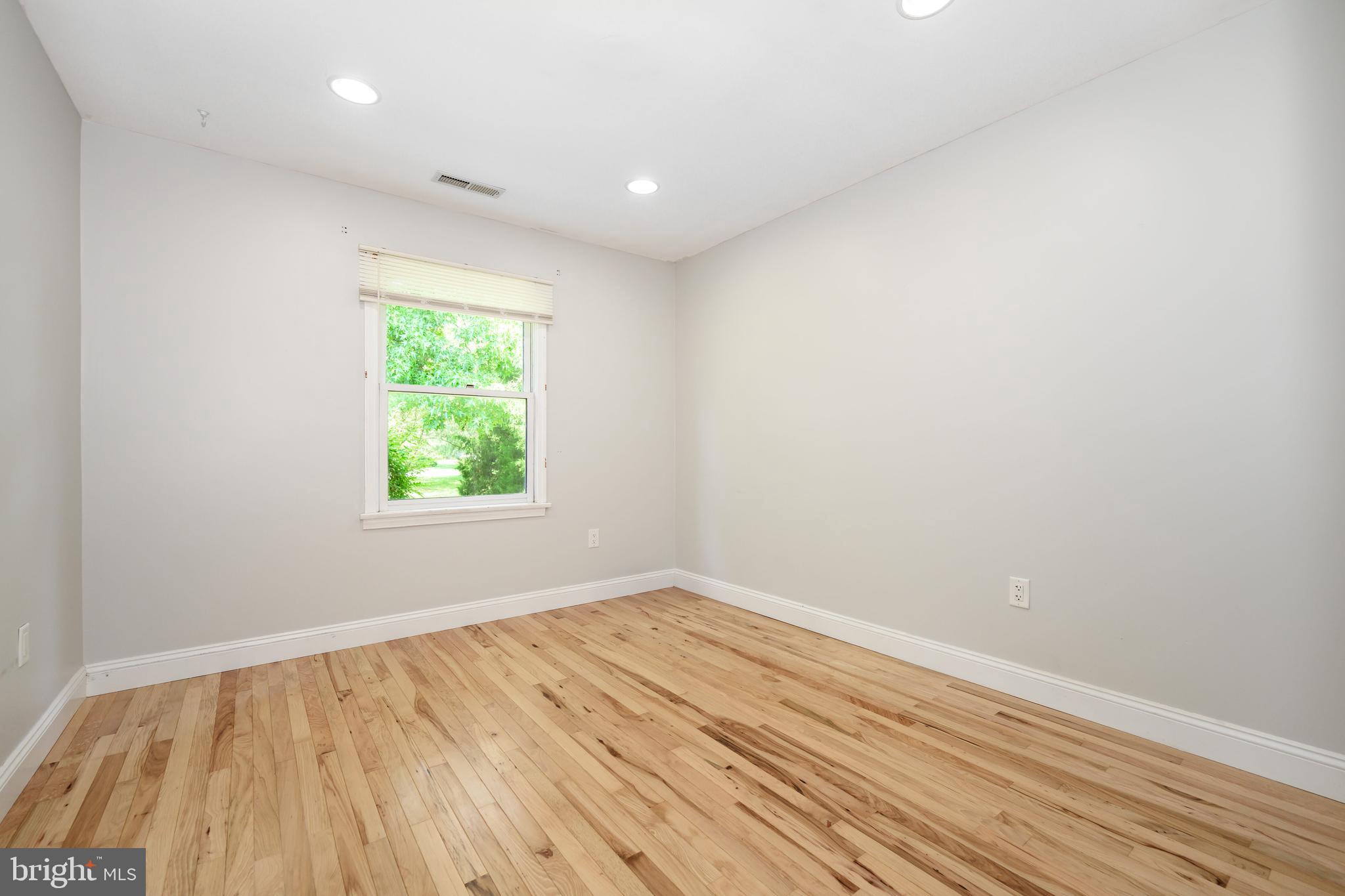 26648 Arcadia Shores Road Easton, MD 21601 - Photo 19 of 25 an empty room with wooden floor and windows