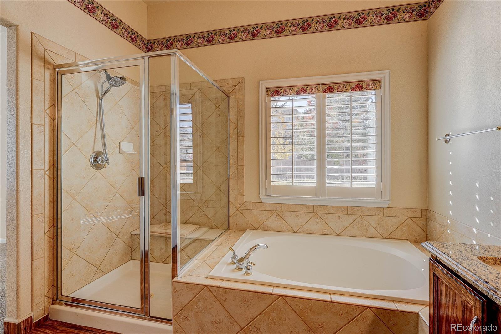 10292 South Nickolas Avenue Highlands Ranch, CO 80124 - Photo 23 of 46 a bathroom with a tub and a shower