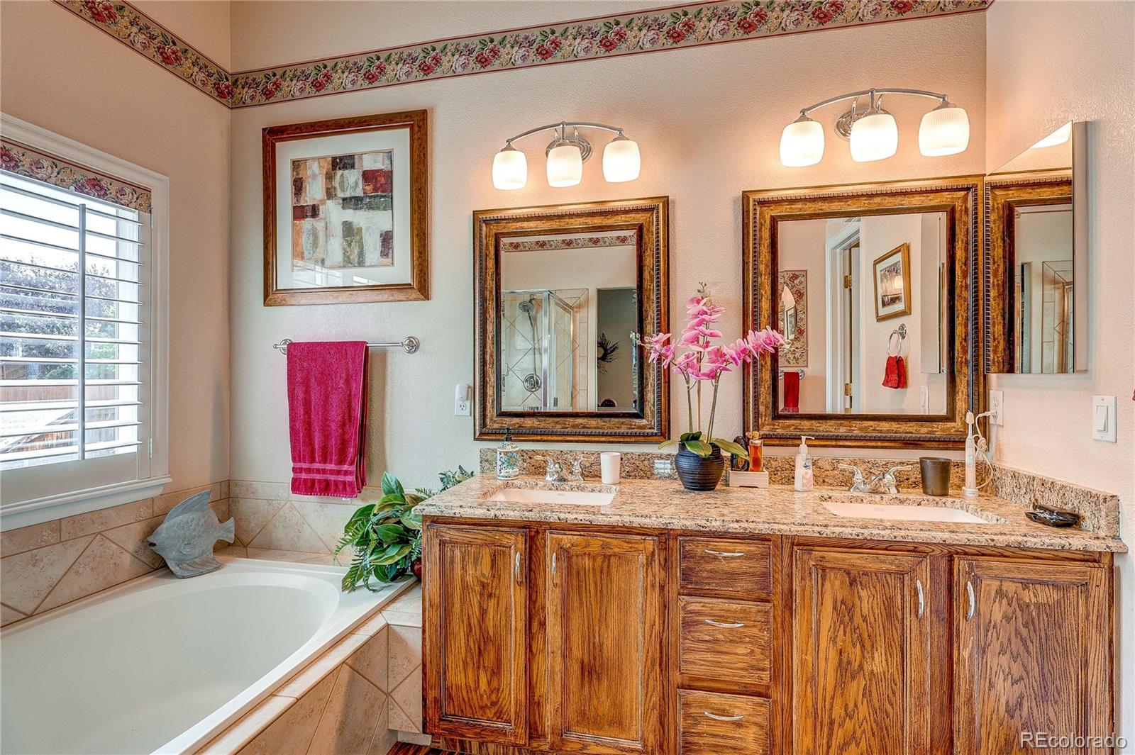 10292 South Nickolas Avenue Highlands Ranch, CO 80124 - Photo 24 of 46 a bathroom with a granite countertop double vanity sink a mirror and a window