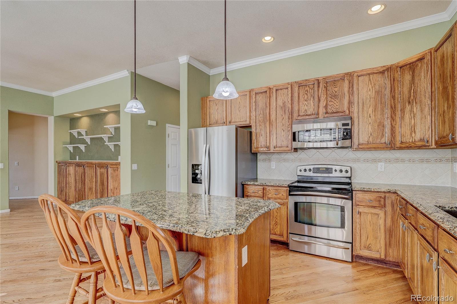 10292 South Nickolas Avenue Highlands Ranch, CO 80124 - Photo 4 of 46 a kitchen with stainless steel appliances granite countertop a kitchen island hardwood floor and a sink