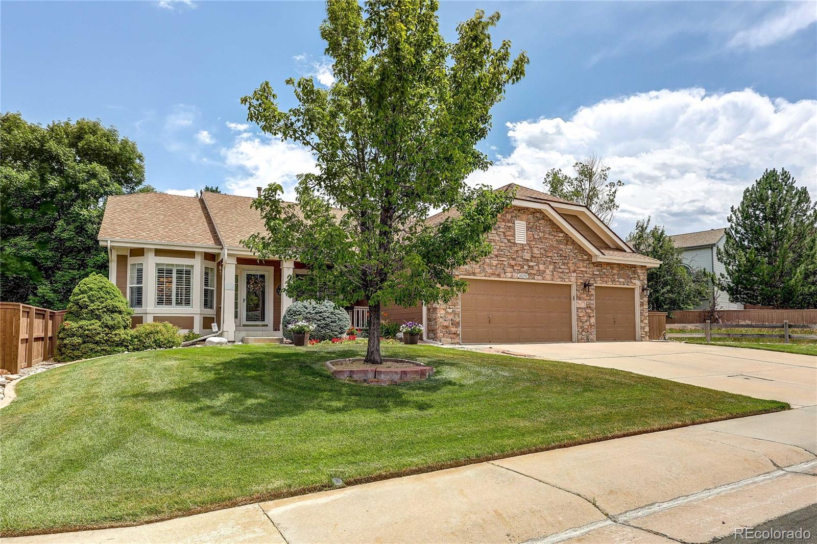 10292 South Nickolas Avenue Highlands Ranch, CO 80124 - Photo 45 of 46 a front view of a house with a garden and trees