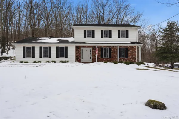 a front view of a house with yard covered in snow
