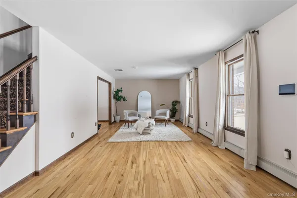 a view of a living room and bathroom with wooden floor