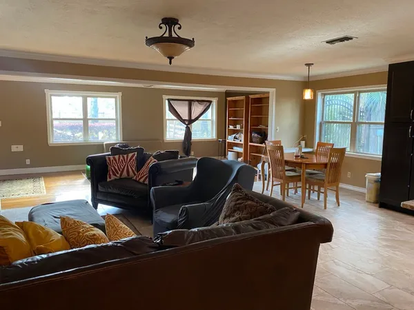 a living room with furniture a large window and flat screen tv