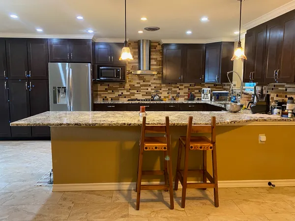 a kitchen with stainless steel appliances granite countertop a sink and a refrigerator