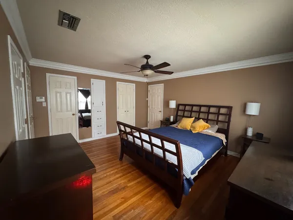 a bedroom with a bed and wooden floor