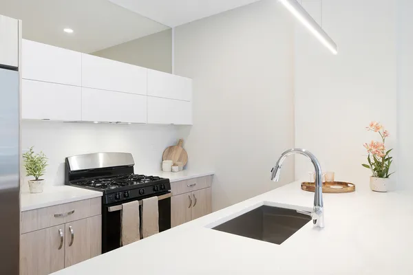 a kitchen with granite countertop a sink a stove and a microwave