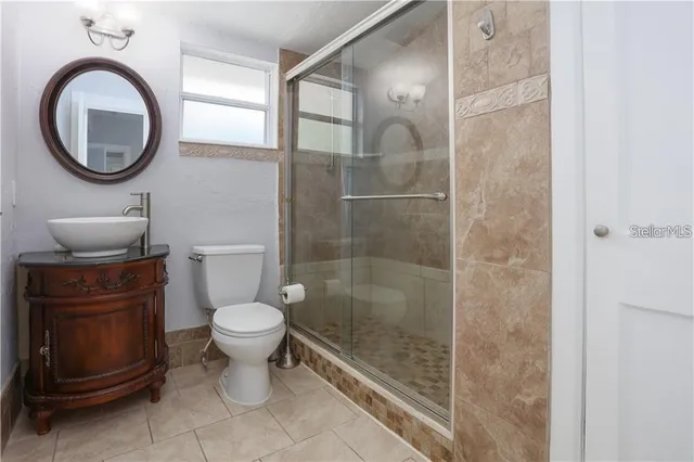 an empty room with wooden floor cabinet and windows