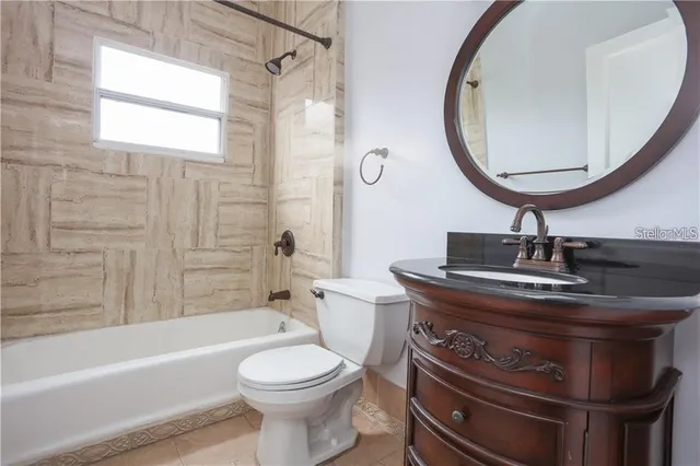 an empty room with wooden floor ceiling fan and windows