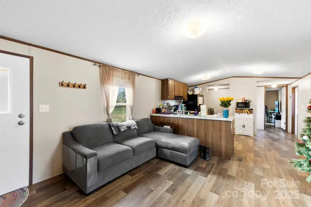 a kitchen with granite countertop a stove top oven a sink dishwasher and a refrigerator with wooden floor