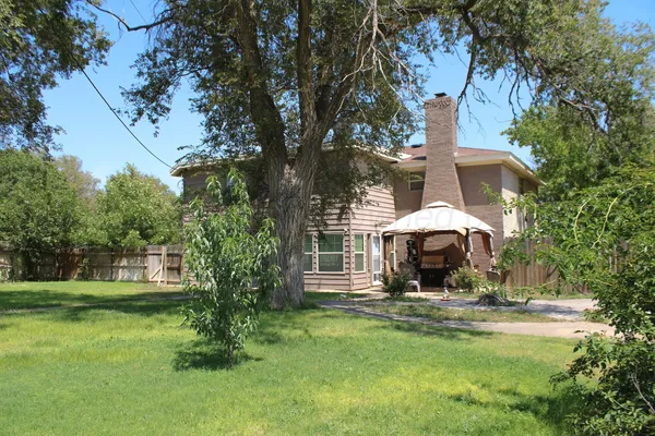 a view of a house with backyard and sitting area