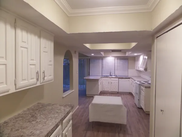 a kitchen with stainless steel appliances granite countertop a sink and dishwasher with wooden cabinets