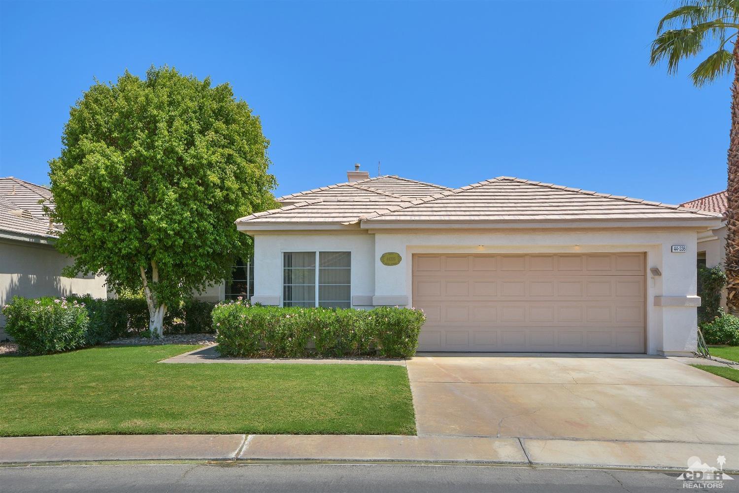a front view of a house with a garden and yard