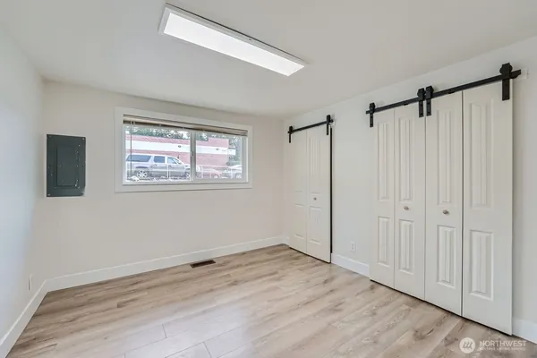 a view of a room with wooden floor closet and windows