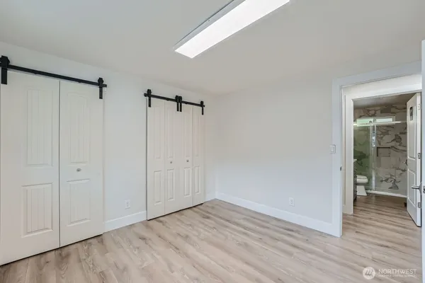 a view of an empty room with closet and a window
