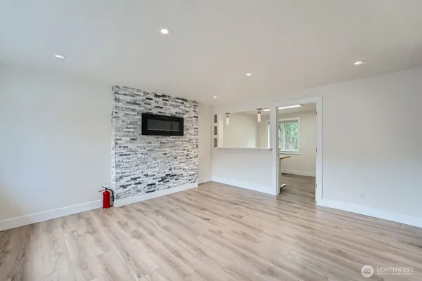 a view of empty room with wooden floor and fireplace