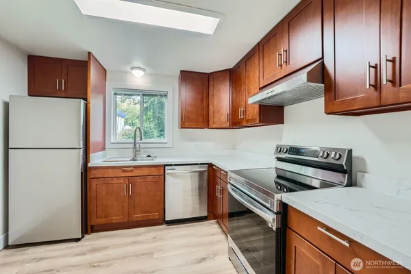 a kitchen with stainless steel appliances granite countertop a sink stove and refrigerator