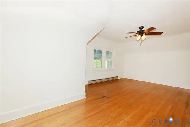 an empty room with a window and a ceiling fan