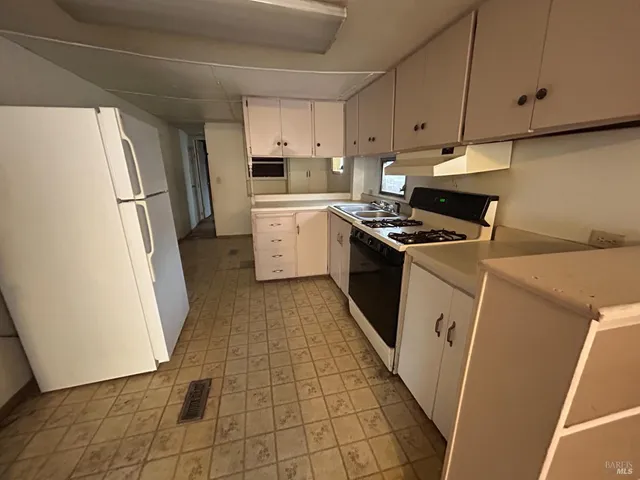 a kitchen with a stove a refrigerator and a sink
