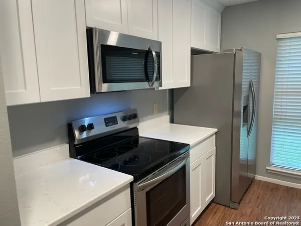 a kitchen with stainless steel appliances a stove a microwave a sink and cabinets