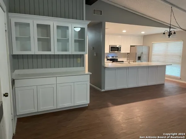 a living room with kitchen island granite countertop furniture and a wooden floor