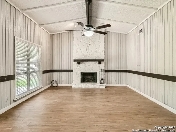 a view of empty room with fireplace and wooden floor