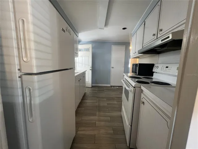 a view of a kitchen with electric appliances