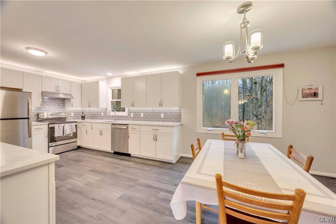 2559 Mountain Road Slatington, PA 18080 - Photo 7 of 32 a large white kitchen with a stove a sink dishwasher and a refrigerator with wooden floor