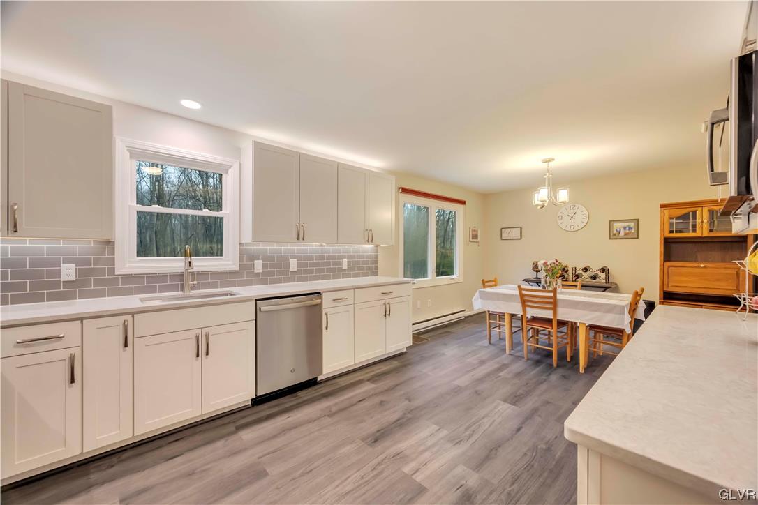 2559 Mountain Road Slatington, PA 18080 - Photo 9 of 32 a large kitchen with kitchen island a sink dishwasher a dining table and chairs with wooden floor