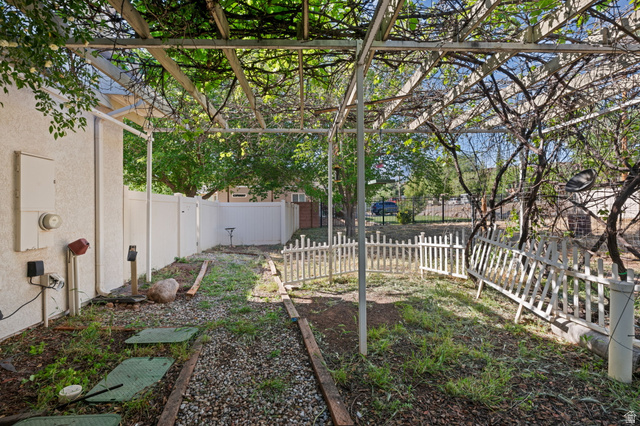 20 Valley Road Leeds, UT 84746 - Photo 30 of 57 Backyard featuring a vine-covered pergola, white privacy fencing, and a decorative white picket fence