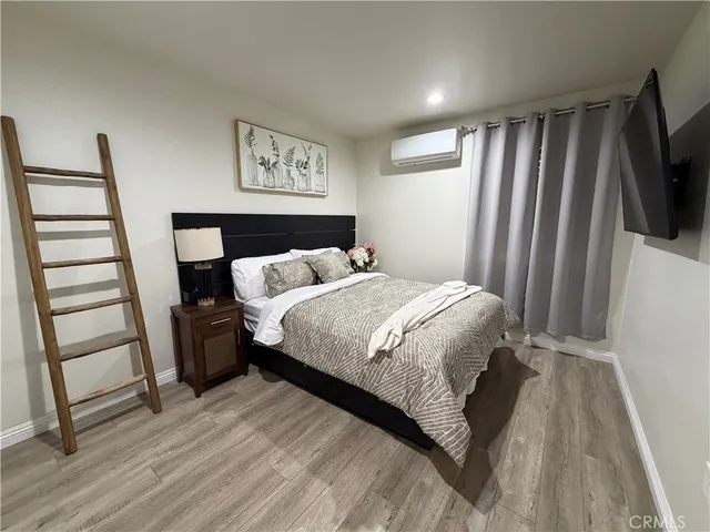 a bedroom with a bed a flat screen tv and a table