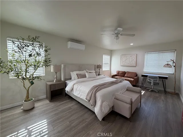 a bedroom with a bed couch and a potted plant