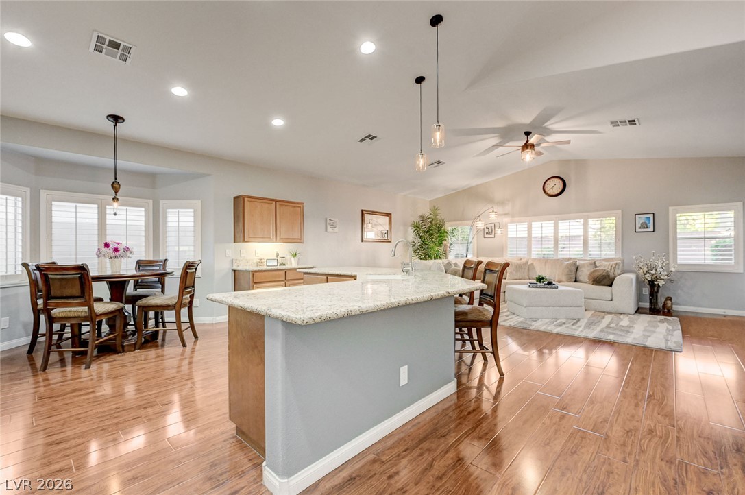 1604 Cattle Ranch Place Henderson, NV 89002 - Photo 17 of 99 An inviting open-concept living space features warm hardwood floors and a spacious kitchen island.
