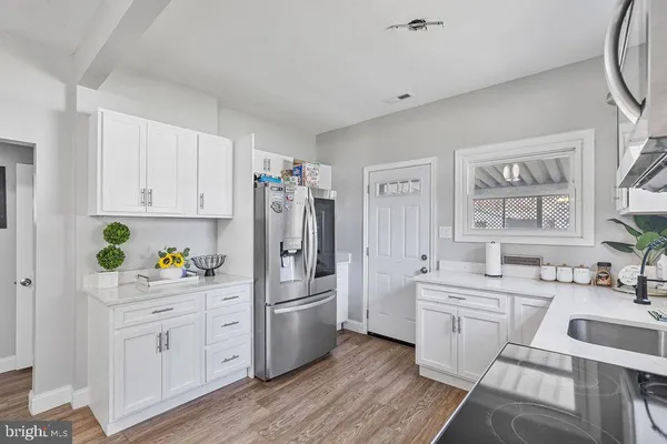 a kitchen with white cabinets and refrigerator