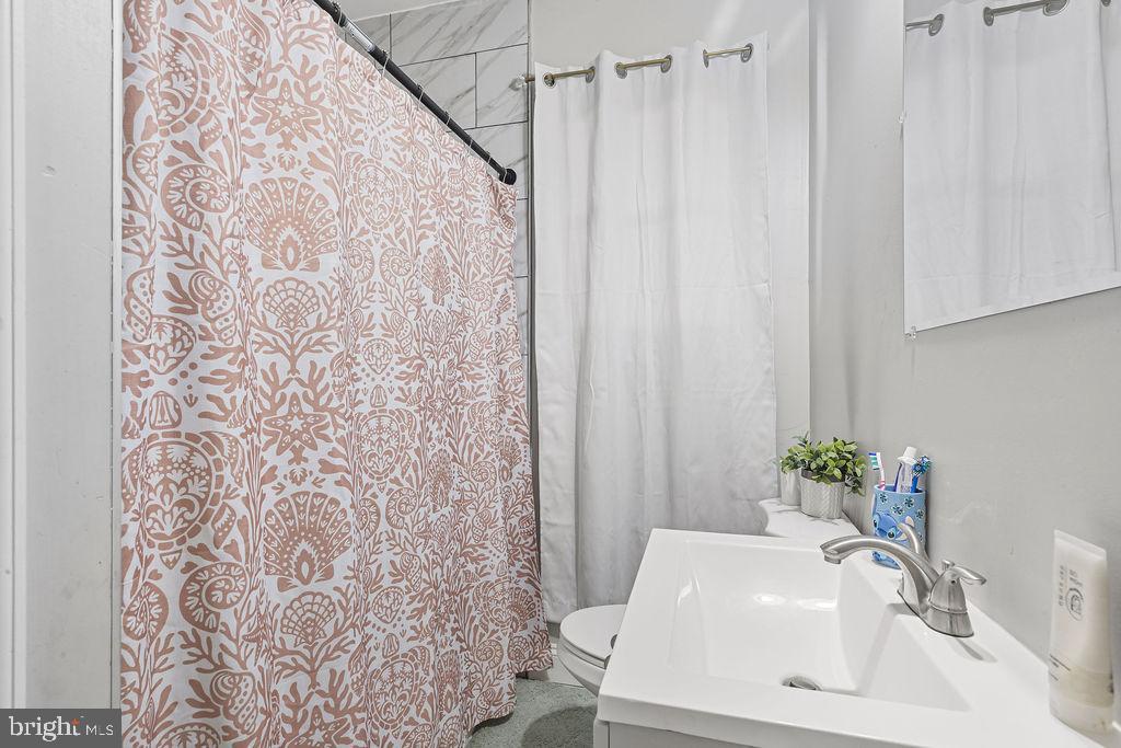 8489 Arbutus Road Pasadena, MD 21122 - Photo 20 of 41 a bathroom with a sink and a mirror