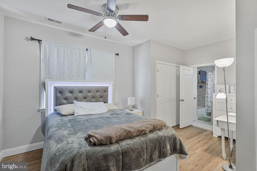 8489 Arbutus Road Pasadena, MD 21122 - Photo 23 of 41 a bedroom with a large bed and a chandelier