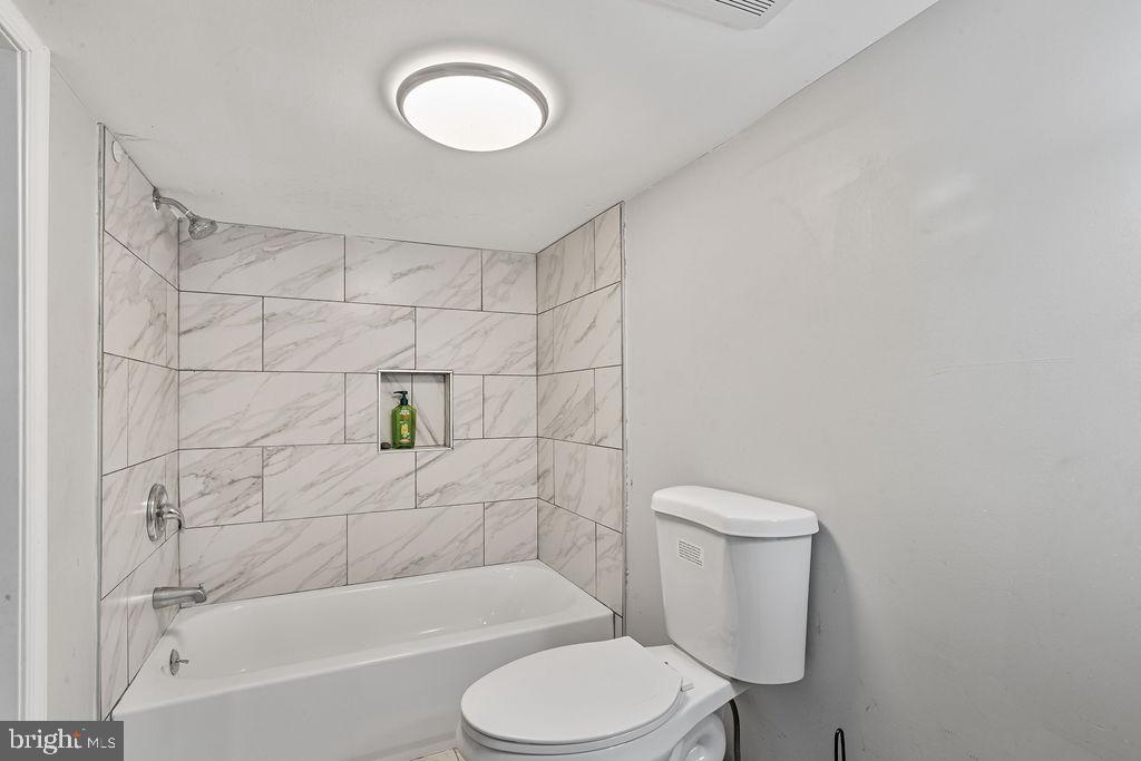 8489 Arbutus Road Pasadena, MD 21122 - Photo 26 of 41 a bathroom with a toilet and a bathtub