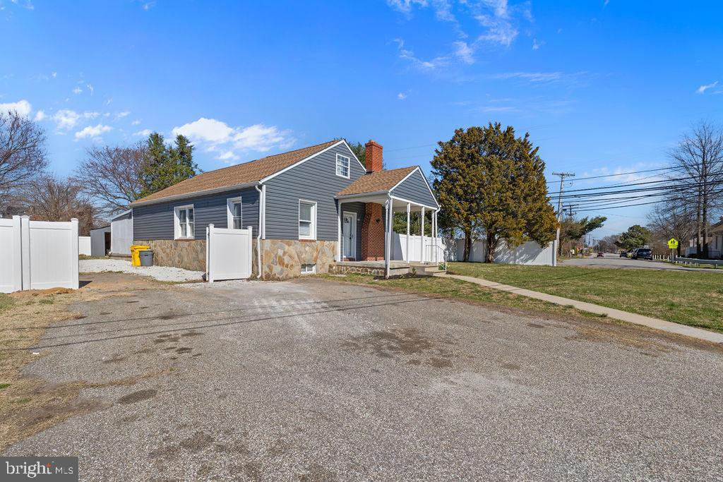 8489 Arbutus Road Pasadena, MD 21122 - Photo 3 of 41 a front view of a house with a garden